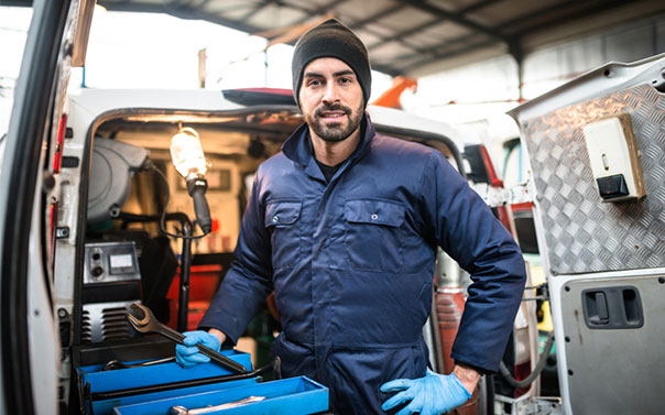 A business owner standing in front of his work truck